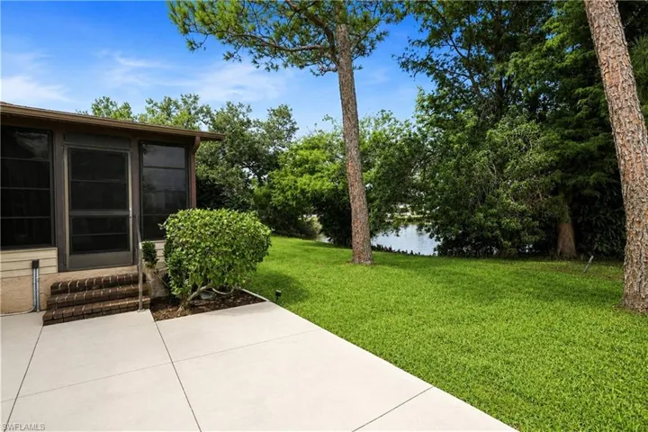 Screened patio with brick steps, concrete landing, and lush green lawn