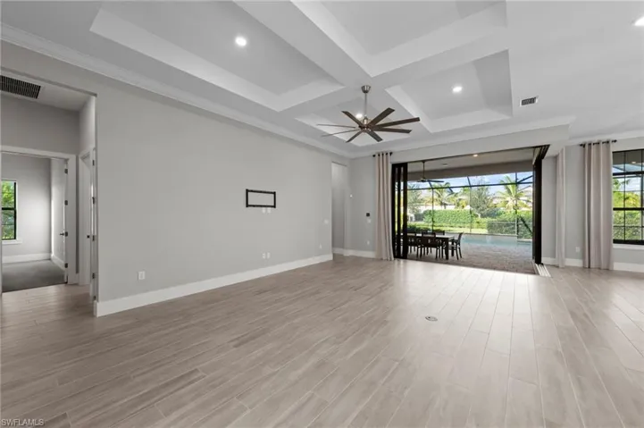 Unfurnished living room with light wood-style flooring, coffered ceiling, ornamental molding, recessed lighting, and beam ceiling