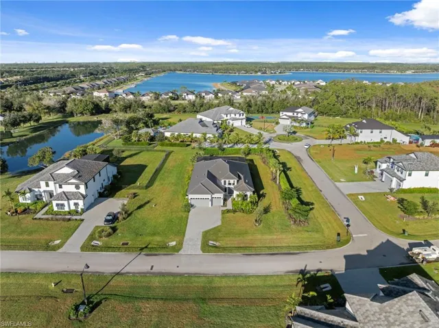 Aerial view of property and surrounding area with a large body of water and nearby suburban area