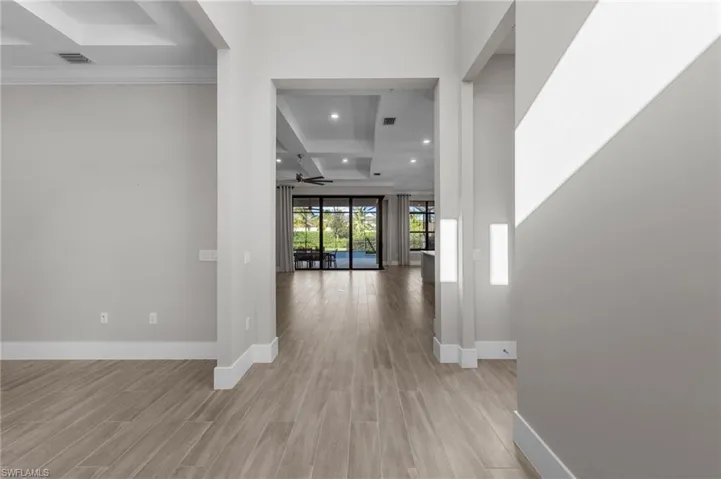 Hallway with light wood-style floors, coffered ceiling, beamed ceiling, and recessed lighting