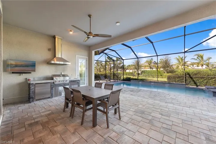 View of patio / terrace with a sunroom, area for grilling, ceiling fan, an outdoor pool, and outdoor dining area