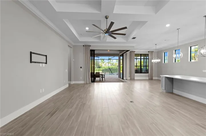 Unfurnished living room with coffered ceiling, light wood-style floors, a ceiling fan, recessed lighting, and beamed ceiling