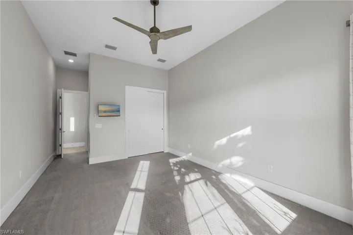 Unfurnished bedroom with carpet, a closet, and a ceiling fan