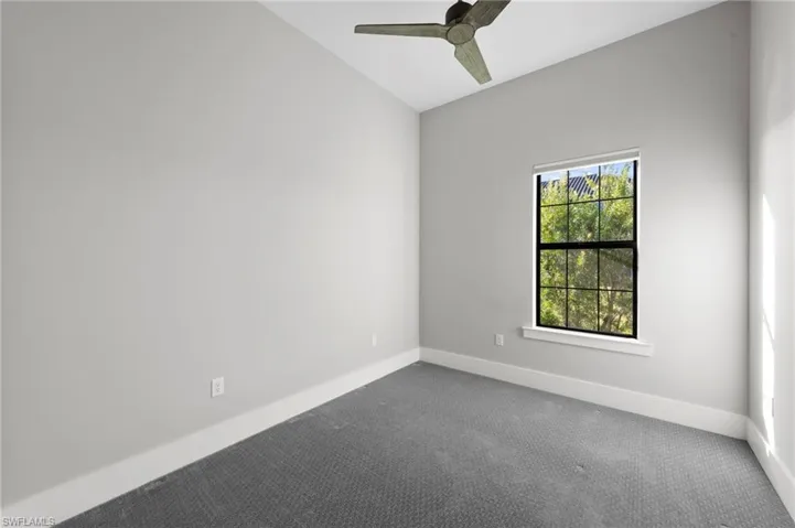 Empty room featuring carpet floors and a ceiling fan