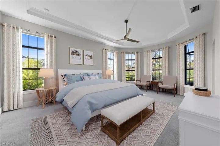 Bedroom with a tray ceiling and carpet