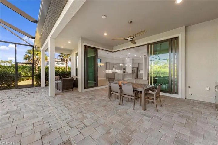 View of patio / terrace featuring a sunroom, a ceiling fan, outdoor dining area, and a lanai