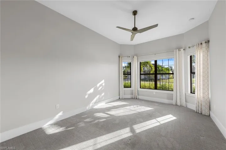 Unfurnished room featuring carpet and a ceiling fan