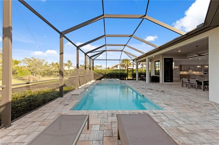 View of pool featuring a patio area, glass enclosure, a sunroom, ceiling fan, and a pool with connected hot tub