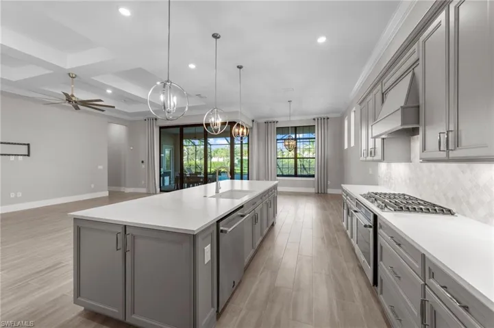 Kitchen with gray cabinets, recessed lighting, light wood-type flooring, open floor plan, and coffered ceiling