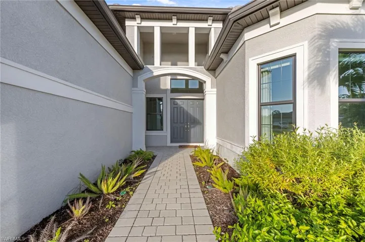 Doorway to property featuring stucco siding