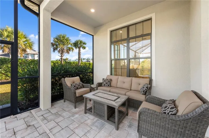 Sunroom with a textured wall, stone tile floors, outdoor lounge area, and recessed lighting