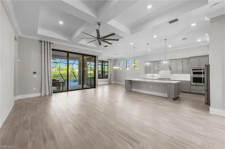Unfurnished living room with coffered ceiling, recessed lighting, beamed ceiling, light wood finished floors, and ceiling fan