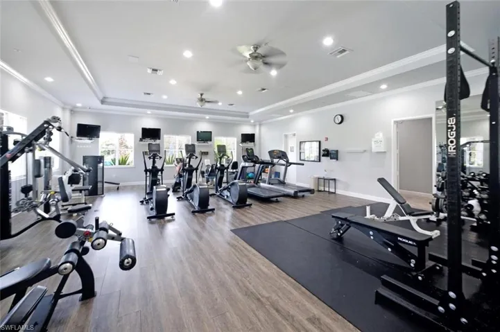 Expansive fitness center featuring wood-finish flooring, recessed lighting, and multiple windows