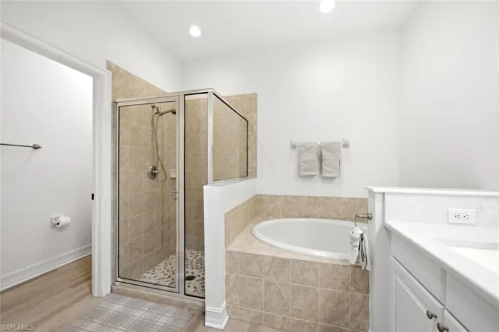 Walk-in shower with clear glass enclosure and pebble-tiled floor
