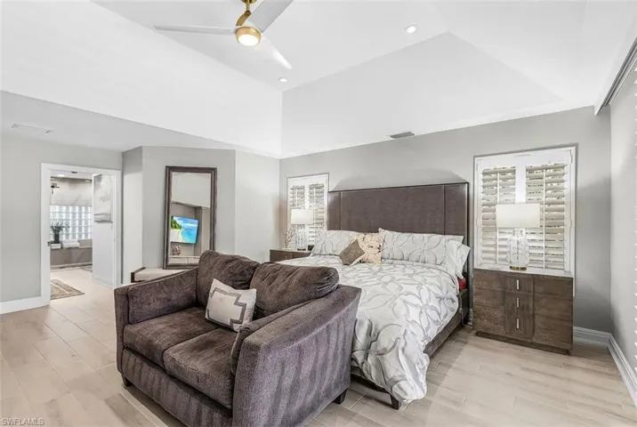 Primary Bedroom with a contemporary ceiling fan, recessed lighting, wood-finish flooring, and plantation shutters