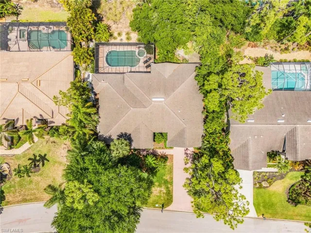 Screened pool and spa with sun shelf, paver patio, and mature landscaping