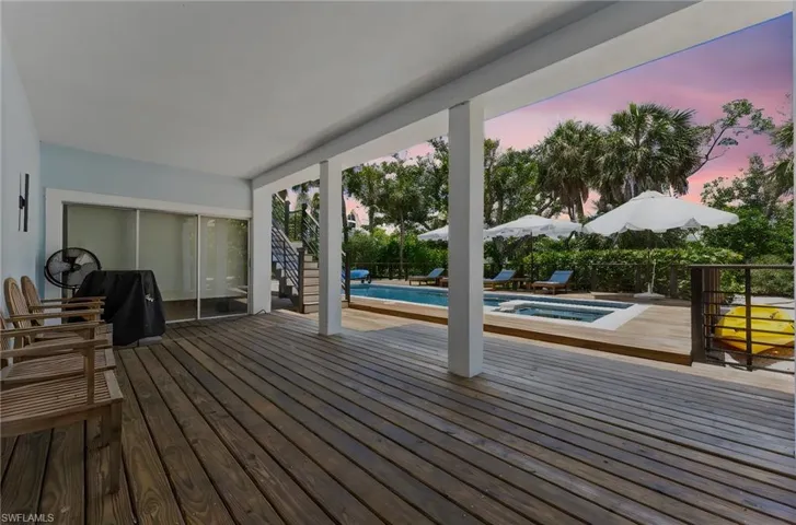 Deck at dusk featuring an outdoor hot tub, a patio area, and stairs