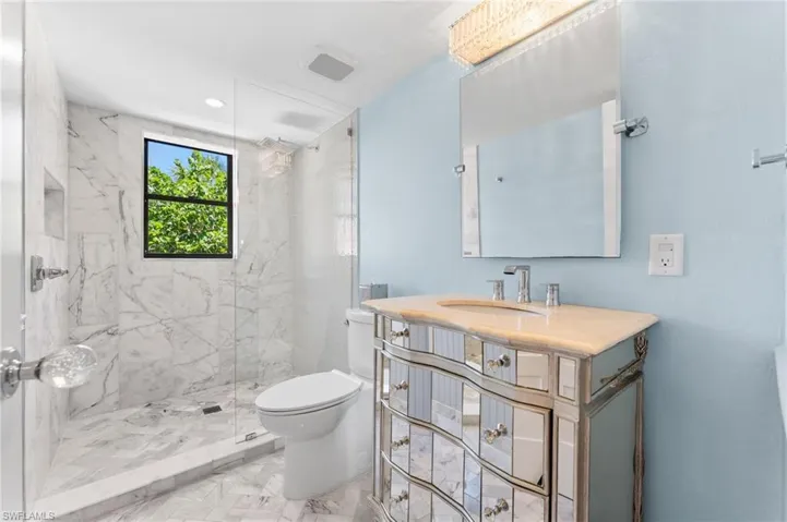 Full bathroom featuring a marble finish shower, vanity, and recessed lighting