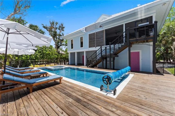View of pool featuring stairway, a deck, a pool with connected hot tub, and a patio area
