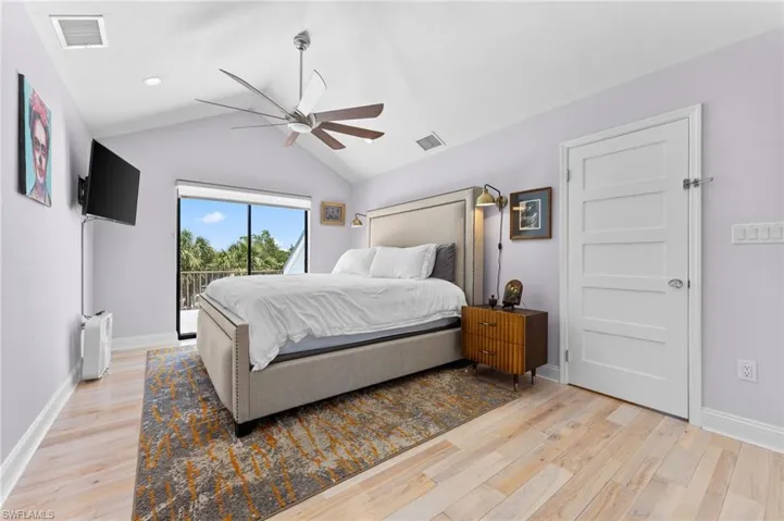 Bedroom featuring lofted ceiling, access to outside, ceiling fan, and light wood-style floors