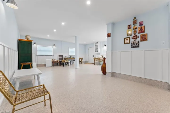 Sitting room with recessed lighting and a wainscoted wall