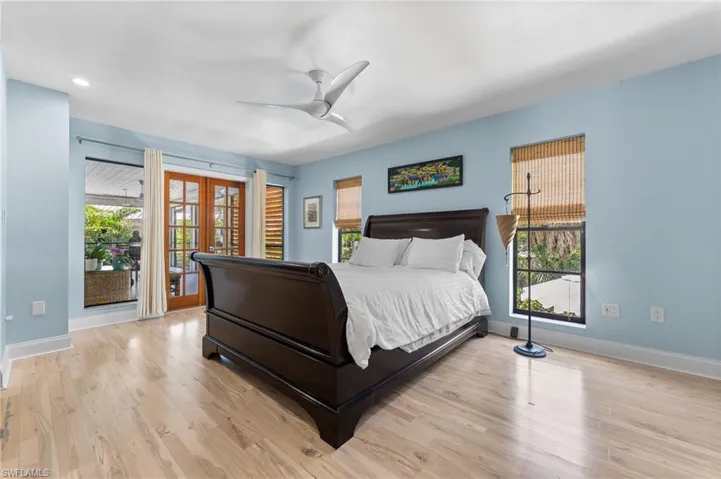 Bedroom with access to exterior, light wood-style flooring, ceiling fan, and french doors