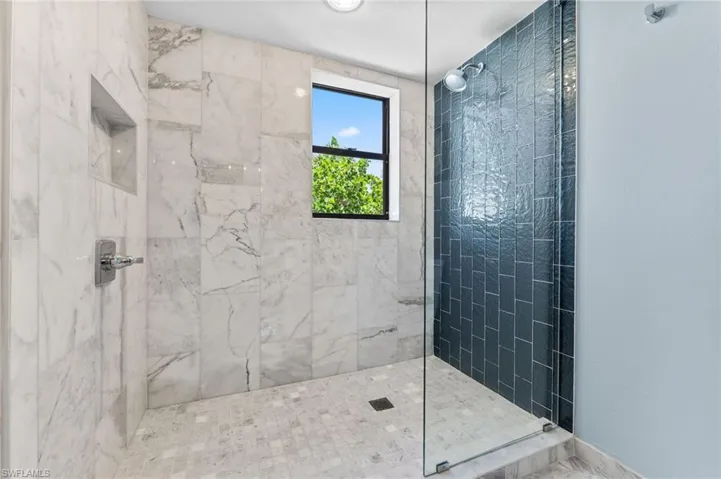 Full bathroom with a marble finish shower