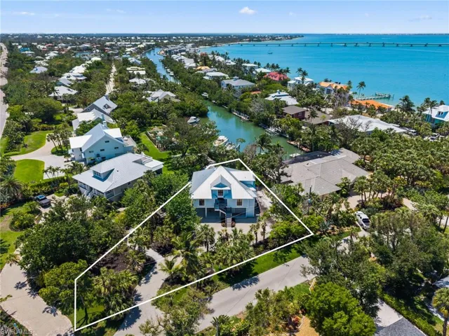 Aerial perspective of suburban area featuring property parcel outlined and a nearby body of water