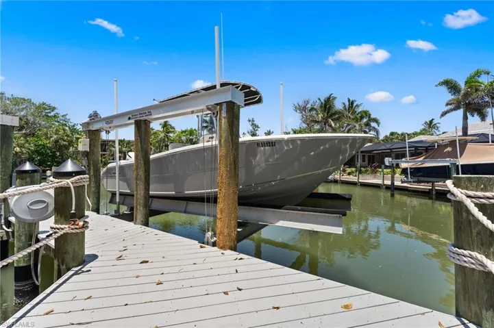 Dock featuring boat lift and a water view