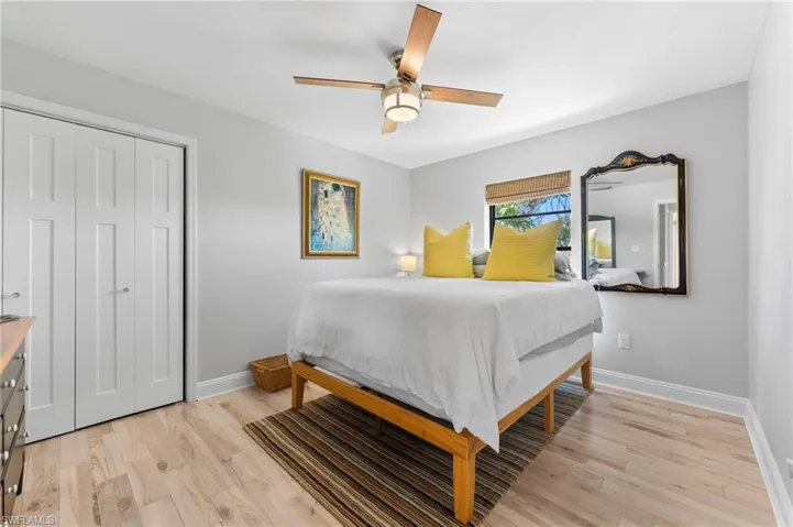 Bedroom with light wood-type flooring, a ceiling fan, and a closet
