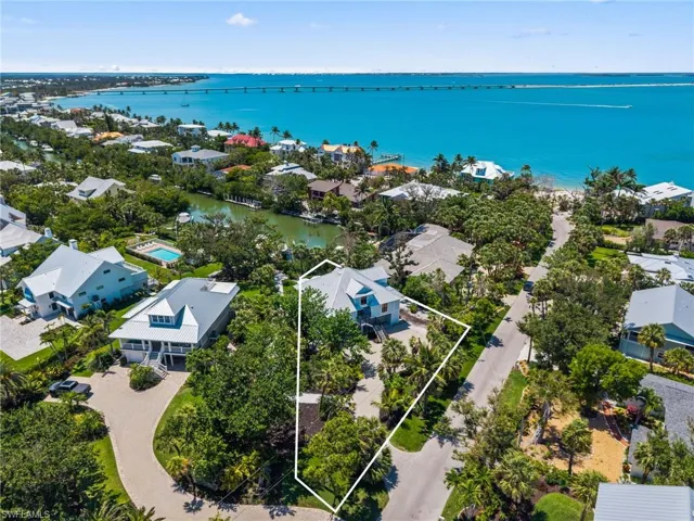 Aerial view of residential area with a large body of water and property boundaries highlighted