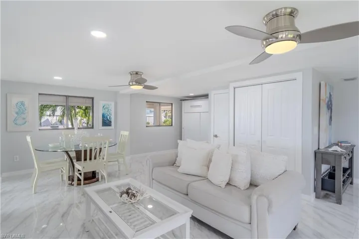 Living area featuring a ceiling fan, recessed lighting, plenty of natural light, and light tile finish flooring - Virtually Edited Image