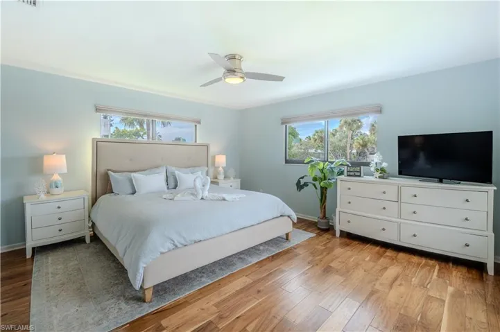 Bedroom with light wood-style floors and ceiling fan - Virtually Edited Image