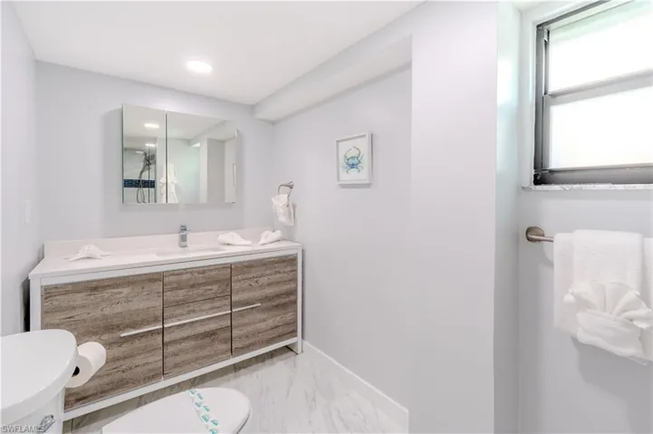 Bathroom featuring vanity and light marble tile finish floors - Virtually Edited Image