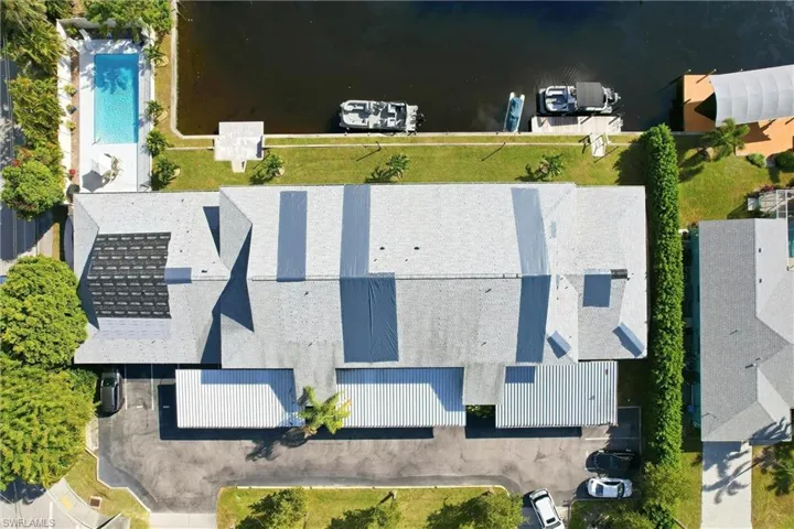 Bird's eye view of a pool area and a nearby body of water