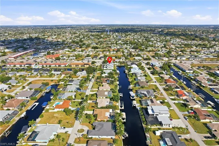 Aerial view of property and surrounding area featuring nearby suburban area
