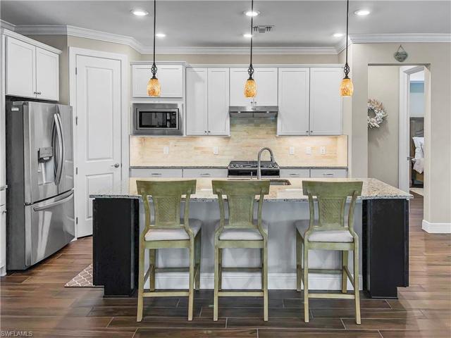 Kitchen features beautiful pendant lighting, upgraded refrigerator/freezer, natural gas stove, spacious pantry and plenty of cabinet space.