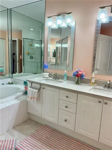 Main bathroom featuring a double vanity, tub and separate shower