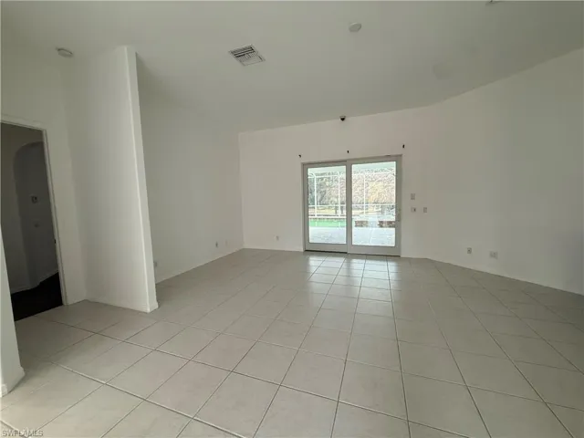 Unfurnished room with light tile patterned floors and arched walkways
