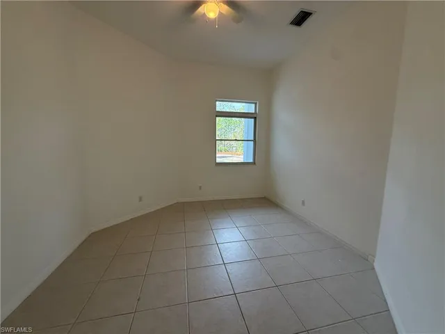 Unfurnished room with light tile patterned flooring and a ceiling fan