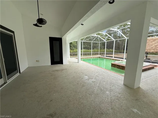 View of swimming pool featuring a sunroom, a patio area, a lanai, and a pool with connected hot tub