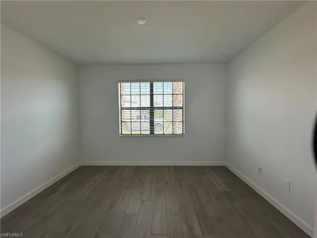 Spare room with dark wood-type flooring