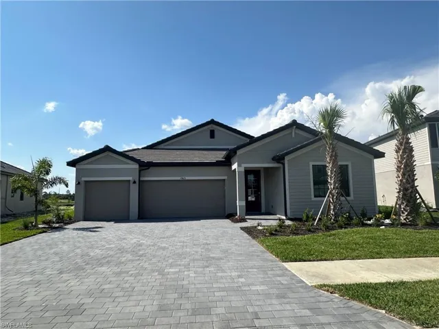 Single story home with a garage and a front lawn