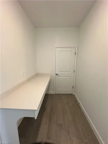 Unfurnished office featuring dark hardwood / wood-style flooring