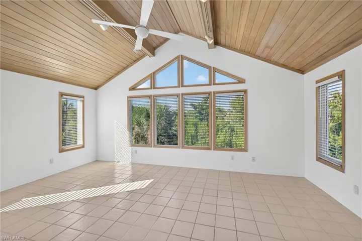 Unfurnished room with wood ceiling, light tile patterned flooring, and a ceiling fan