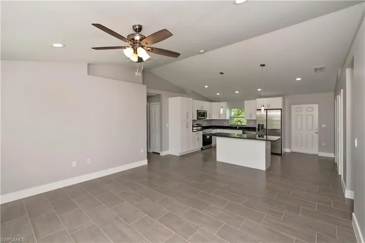 Kitchen featuring visible vents, white cabinets, open floor plan, appliances with stainless steel finishes, and dark countertops