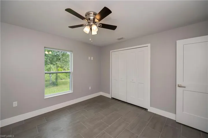 Unfurnished bedroom with visible vents, a closet, a ceiling fan, and baseboards
