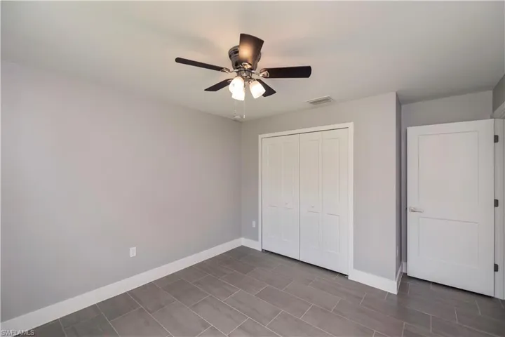 Unfurnished bedroom with a ceiling fan, a closet, visible vents, and baseboards