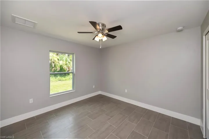 Empty room featuring baseboards, visible vents, and ceiling fan