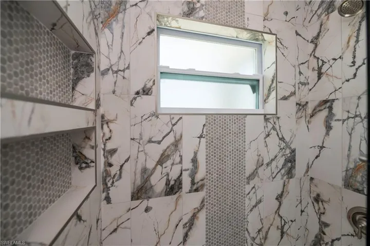 Bathroom featuring a marble finish shower